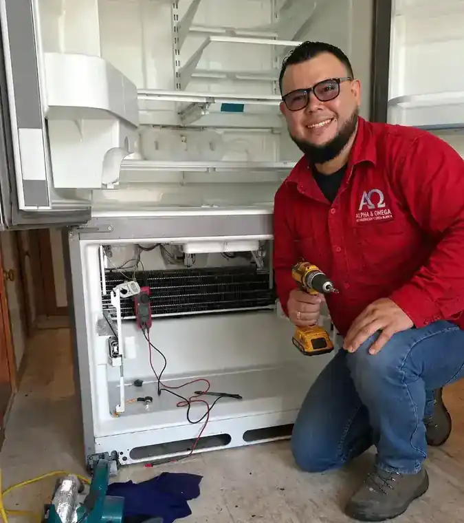 Técnico certificado de Alpha&Omega finalizando reparación de refrigerador